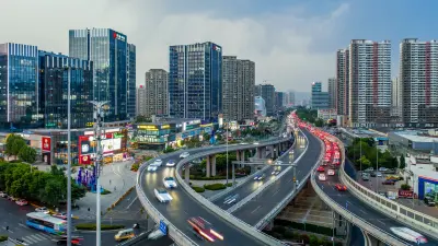 小米SU7驶过北京孔庙附近的一座中式牌楼。 